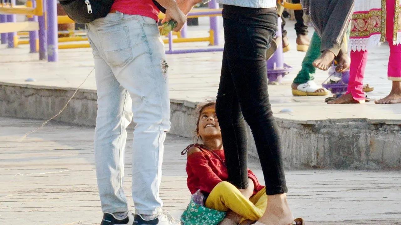 Won’t let you go: A young girl from the Dombari community playfully wraps her arms around a visitor’s leg at Bandstand Promenade on Monday. Pic/Satej Shinde